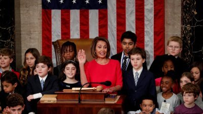 美国众议院民主党领袖佩洛西（中），周四在国会山庄议事厅内，在一群儿童的簇拥下宣誓就任众议院议长。