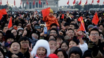 中国前年实施的二胎政策并未使出生率如预期般增加，因而使人日益猜测，北京当局可能会进一步放宽生育限制。图为中国民众周二在北京天安门广场，趁升旗仪式进行时欢庆元旦。
