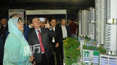 槟州首长曹观友（左2）向祖莱达（左）汇报槟城房地产展销会的情况。（摄影：蔡开国）