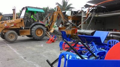 峇株巴辖市议会执法人员出动神手拆除巴力拉惹广 场旁的违建摊档。