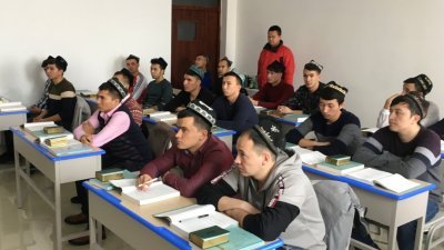 新疆“再教育营”的目的是为了打击极端主义，并帮助营内的学生学习中国国家律法以及汉语。这是乌鲁木齐“再教育营”的学生们，在教室内上课。
