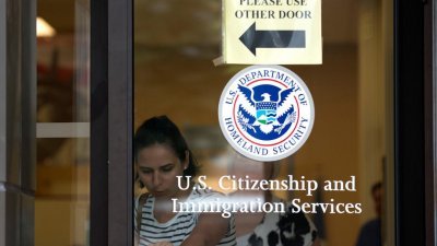 美国总统特朗普在2017年，曾下令修改H-1B工作签证政策，如今他将对该签证作出积极改变。图为一名女子正步离位于纽约的美国公民和移民服务局办公楼。