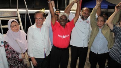 安华（左2）在政治讲座后，高举玛诺嘉南（左3）的手，呼吁选民给予后者支持。左起是符芝雅、哥宾星及林吉祥。