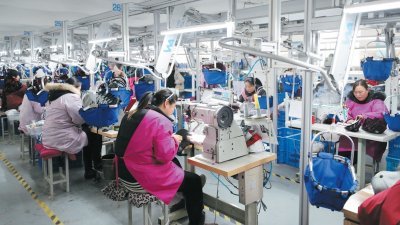 中美贸易战下，中国多个制造业重镇的企业因订单减少，今年均提早放春节假。这是在江苏省连云港的一家纺织厂，工人正在缝制帽子。
