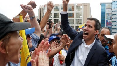 反对派领袖瓜伊多（右）在加拉加斯的示威中，自行完成宣誓就任临时总统。他高举右手高呼，回应欢呼的支持者们。