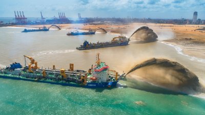 斯里兰卡科伦坡的港口城项目工地上，来自中国的4条大型耙吸挖泥船，同时在吹沙。