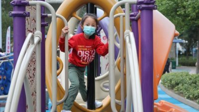香港小朋友带著口罩在公园玩耍。香港正值流感高峰期，幼稚园周六开始全面停课。