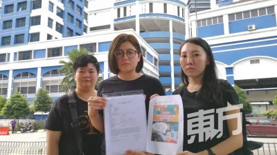 苏仪芳（中）在两名支持者的陪同下，向媒体记者展示报案书及面子书截图。