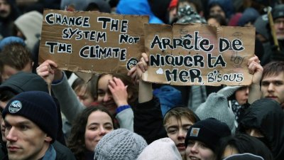 布鲁塞尔民众周日为抗暖化上街游行，有人高举“要改变制度，不要改变气候”的标语。