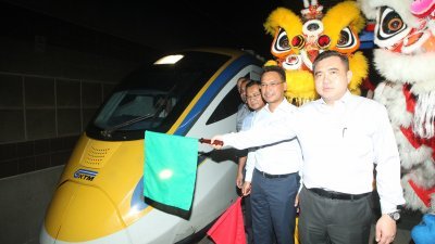 陆兆福（右）为前往北海的双轨火车进行挥旗礼。左为马来亚铁道公司首席执行员莫哈末拉尼。