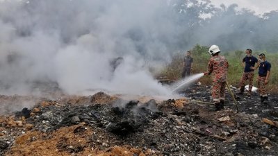 消拯员努力扑灭非法垃圾场的火势，避免火势继续蔓延。
