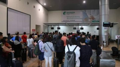 在马六甲峇株安南国际机场准备飞往槟城的乘客排队等待消息。（图片取自网络）