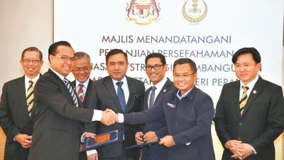 陆兆福（左4）与阿末法依沙（右3）共同见证铁路资产机构总经理阿扎哈（左2）与霹雳州务大臣机构首席执行员安努亚（右2）签署备忘录。左起尼查、卡玛鲁丁及杨祖强。
