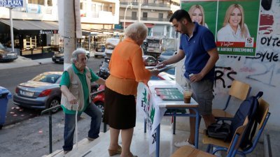 希腊周日举行全国大选，预料选民将重投主流保守派怀抱。图为当天在雅典一个投票站外，当地居民前往投票。