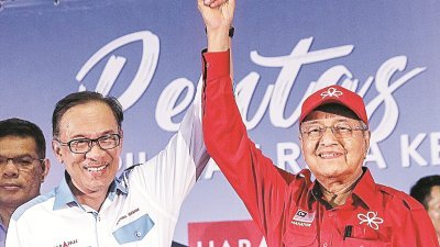马来政坛近期暗涌浮动，首相权位交接不明朗，也让土团党、公正党与巫统领袖动作频频。图为马哈迪（右）与安华在去年9月在一场活动上互相牵手。