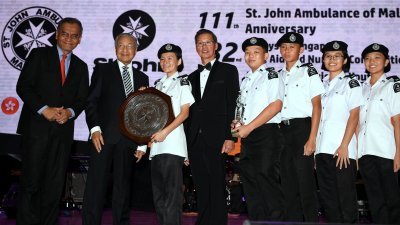 马哈迪（左2）颁发亚太地区青少年急救竞赛挑战奖杯予获奖的大马队成员。左为祖基菲里阿末及拿督赖斯明（左4）。
