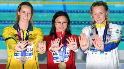 女子100公尺蝶泳金银牌得主——麦克尼尔（中）、舍斯特伦（右起）和麦基恩，在领奖后伸出手掌，隔空为罹患白血病的日本游泳选手池江璃花子打气，成为暖心一幕！