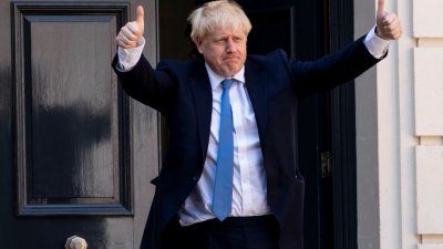 新当选保守党党魁和英国新一任首相的约翰逊，周二抵达保守党总部时，以胜利者姿态向传媒高举双手比出大拇指。