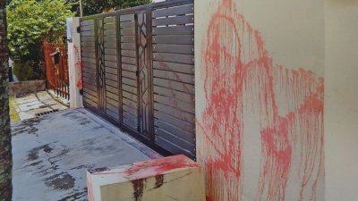 蒋义秀的住家铁门和外墙被泼上红漆，怀疑是大耳窿点错相或通过她向欠债的邻居施压。