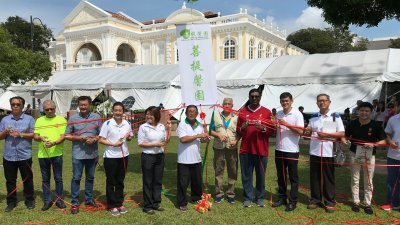 林秀琴（左5起）及陈瑞万等人，于周日上午为菩提馨园慈善义卖会主持开幕仪式。左8起为日落洞国会议员雷尔及峇都兰樟州议员王耶宗。