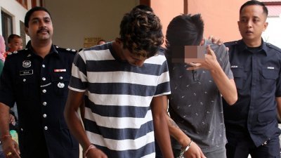 涉嫌非法放贷及恐吓借贷人的古鲁巴山（左2起）及未成年的华裔少年，周一遭警方押往法庭面控时，全程低头以避开媒体的摄像镜头。