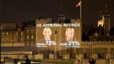 反脱欧组织Led By Donkeys在伦敦塔桥的墙面上，投影奥巴马和特朗普的头像，以及两人在英国的支持率。