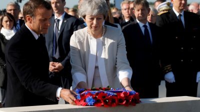 英国首相特丽莎梅（中）于周五辞去保守党党魁，新任领袖将于下周一开放提名。这是她在法国诺曼底登陆日75周年纪念活动上，与法国总统马克龙一齐为当年阵亡的士兵献上花圈。