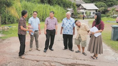 陈国耀（左3）聆听村民对道路破损的投诉，左2为张庆隆，右为纪秋慧。