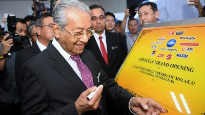 首相敦马哈迪在马六甲出席活动时，为精明工业中心主持开幕礼，并签下大名。