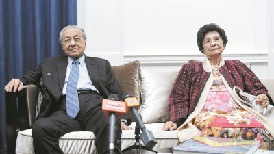马哈迪（左）在夫人敦西蒂哈斯玛陪同下，于马来西亚驻伦敦最高专员署召开记者会，接受大马随团媒体的访问。