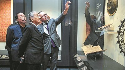 马哈迪（中）参观大英博物馆，专注聆听佐哈纳丹的解说。左为成功集团创办人丹斯里陈志远。