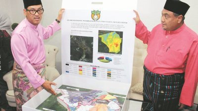 阿末费沙（左）向媒体展示被鉴定发展为农业谷的地形模型。