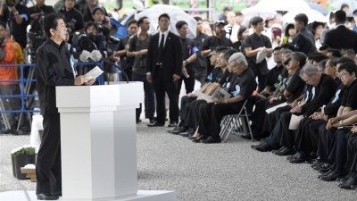 日本冲绳县周日追悼冲绳战役阵亡者，首相安倍晋三（前左）出席致词，遭台下民众呛“滚回去”。
