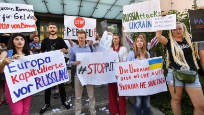 社运人士在乌克兰首都基辅的德国大使馆外集会，举出标语牌抗议德国于欧洲理事会议员大会，投票赞成恢复俄罗斯在该组织的所有权利。