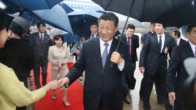 前往日本大阪出席G20峰会的习近平，周四下午抵达关西机场。习近平在大雨中撑伞步出专机，与在场接机人士握手。