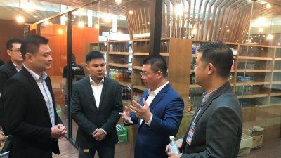倪可敏（右2）视察智能商店开幕准备工作，与Ximplicity首席执行员黄维彬（左）等人讨论细节。