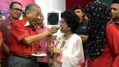 马哈迪（左2起）周六出席其国会选区的开斋节门户开放活动上，甜蜜喂夫人西蒂哈斯玛吃蛋糕。