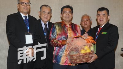 黄敬发（右）赠送水果礼篮予沈志勤（中），感谢他为马来西亚菜业联合总会第23届第一次全国代表大会主持开幕。左起为锺德强、杨集东和郭海强。（摄影：徐慧美）