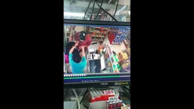 闭路电视摄下嫌犯持刀打劫杂货店的过程。