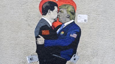 意大利街头艺术家TvBoy在米兰的一面墙上，画上名为<Smart Love>的壁画。手持苹果智能手机的中国国家主席习近平，和手拿华为智能手机的美国总统特朗普相拥亲吻。
