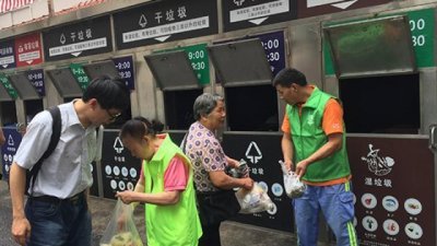 上海周一起实行《上海市生活垃圾管理条例》，条例规定了生活垃圾需按照可回收物、有害垃圾、湿垃圾、乾垃圾等4中来分类。这是民众在不同种类的垃圾箱前进行分类。