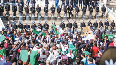 上周五在阿尔及利亚首都阿尔及尔，数以万计人手持国旗和标语牌上街抗议总 统布特弗利卡再次寻求连任，并与一字排开的镇暴警察对峙。