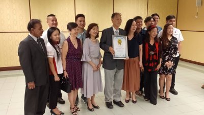 温文京（前排左5）获李佩玲（左2）颁发大马纪录大全最年 长小提琴独奏表演者证书后，与家人和朋友分享这份喜悦。