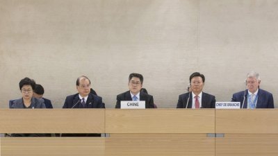 中国副外交部长乐玉成（中）周五在瑞士日内瓦万国宫，出席联合国核可中国国别人权审议报告会议。他在回答记者提问时表示，中国政府在新疆设立的教育培训中心，并非再教育营。