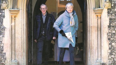 英国首相特丽莎梅的脱欧协议草案两 次遭国会否决，本周将再次在国会闯 关。图为特丽莎梅（右）周日与丈夫 菲利普一同离开桑宁教堂。