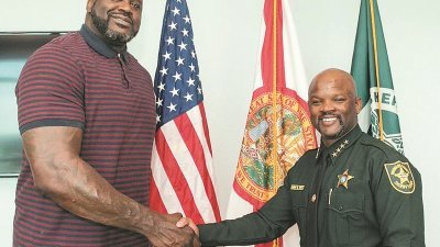 美国佛罗里达布劳沃德县警察局，正式聘请前NBA巨星奥尼尔（左）担任该警局副警长。