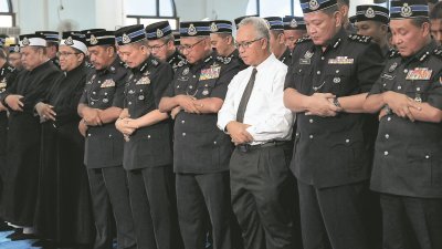 弗兹（右4）在内政部副秘书长拿督再纳阿比丁（右3）及众警员陪同下，进行祈祷仪式。