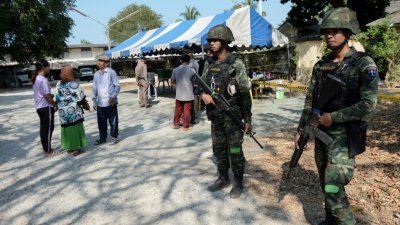 在动荡不安的泰南，陶公府的其中一所投票站外，可见全副武装的士兵驻守。