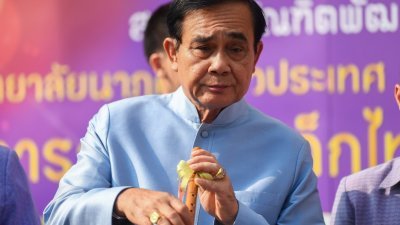 泰国首相巴育周二出席内阁会议，在他抵达政府大楼时吹奏传统长笛。