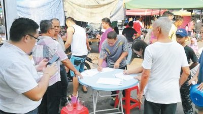 民众积极响应委员会在庆隆花园小贩中心进行的抗议垃圾废料签名运动。
